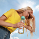 Woman with a bottle of water suffering from heat stroke outdoors